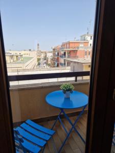 een blauwe tafel en 2 stoelen op een balkon bij Casa Rosetta in Lecce