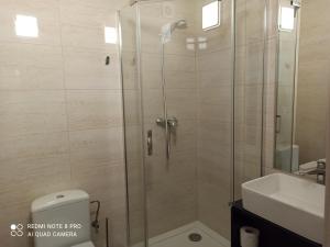 a shower with a glass door next to a sink at HOTEL ODR in Sulechów