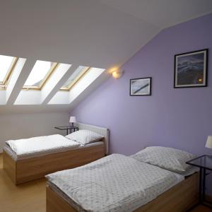two beds in a attic room with skylights at Magnat w Borczu in Borcz