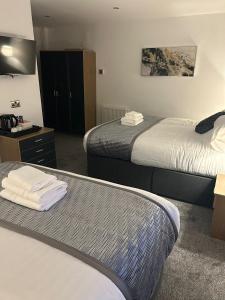 a hotel room with two beds and a dresser at Woodhouse Hotel Fully refurbished quiet family hotel No stag or hens all will be refused on checkin in Blackpool