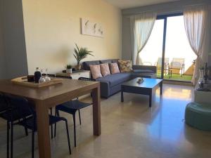 een woonkamer met een blauwe bank en een tafel bij Superbe appartement penthouse in Manilva