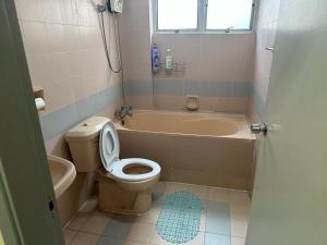 y baño con aseo, bañera y lavamanos. en Bukit Tinggi 1 Hati guesthouse en Bukit Tinggi