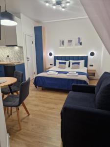 ein Schlafzimmer mit einem Bett, einem Tisch und einem Sofa in der Unterkunft DeMar Apart STAR in Lwiw