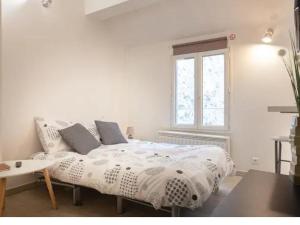 フォンテーヌブローにあるle studio by sleepinfontainebleauの白いベッドルーム(ベッド1台、窓付)