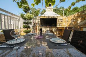 a table with plates and wine glasses on a patio at Apartments Kapetan in Trogir