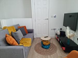 a living room with a gray couch and a table at Central Watford Modern Apartment - Travellers & Contractors Welcomed in Watford
