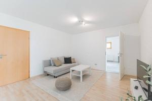 a living room with a couch and a table at G01 schöne Souterrainwohnung - Self Check-In ideal für Teams und Monteure in Gäufelden