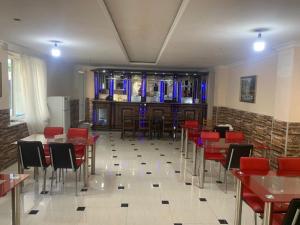 a restaurant with red chairs and tables and a bar at Amfitrita Hotel Ureki in Ureki