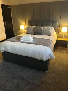 a bed in a room with two lamps and towels on it at Woodhouse Hotel Fully refurbished quiet family hotel No stag or hens all will be refused on checkin in Blackpool