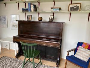 a piano in a room with a chair and a desk at 1 Bedroom Home - Private Balcony - Parking On Site in Tórshavn