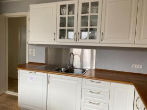 a kitchen with white cabinets and a sink at 1 Bedroom Home - Private Balcony - Parking On Site in Tórshavn