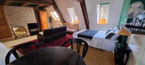 um quarto de hotel com um quarto com uma cama e uma cadeira em Hôtel Particulier des Canonniers em Saint-Quentin