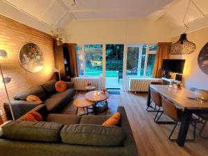 a living room with couches and a table and a dining room at Butterflies, bungalow 134 in Simpelveld