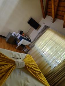 sypialnia z łóżkiem i dużym oknem w obiekcie Emfuleni Boughton Inn w mieście Pietermaritzburg