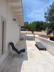 - une terrasse avec une chaise et un banc dans un bâtiment dans l'établissement Montescotano House, à Villa Castelli