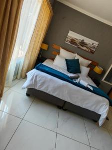 a bedroom with a bed with white sheets and pillows at Emfuleni Boughton Inn in Pietermaritzburg