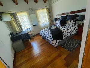 a bedroom with a black and white bed and a desk at Emfuleni Boughton Inn in Pietermaritzburg