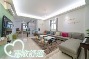a living room with a couch and a table at Happy play villa in Yuanshan