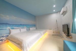 a bedroom with a large bed with a view of the ocean at Happy play villa in Yuanshan