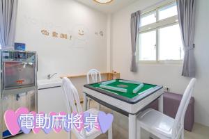 a kitchen with a ping pong table and chairs at Happy play villa in Yuanshan
