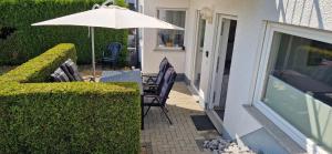 un patio con due sedie e un ombrellone di Ferienwohnung Am Philosophenweg a Hachenburg