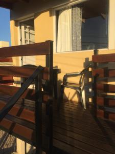 une chaise assise sur le pont d'une maison dans l'établissement Depto temporario carlos paz, à Villa Carlos Paz 2 autres photos