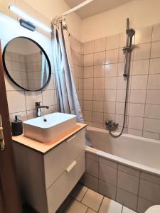 een badkamer met een wastafel, een bad en een spiegel bij City Center Golden Roof 5 in Innsbruck
