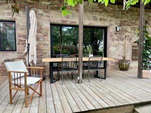 a wooden table and chairs on a wooden deck at La Grange des Duc(s) in Eckbolsheim