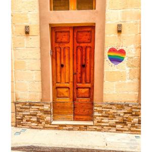 una puerta de madera en un edificio con arco iris en Azure Gold Apartment, en Senglea