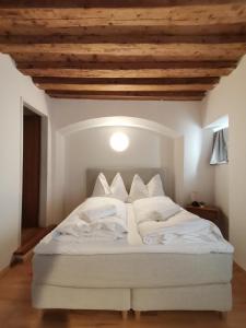 een wit bed in een kamer met een houten plafond bij City Center Golden Roof 5 in Innsbruck