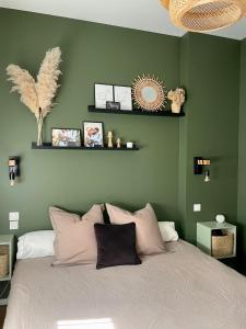 a bedroom with green walls and a bed with pillows at La Grange des Duc(s) in Eckbolsheim