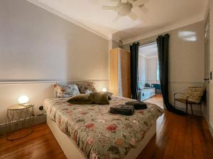 a bedroom with a bed with a comforter on it at Prédio da Estação in Porto