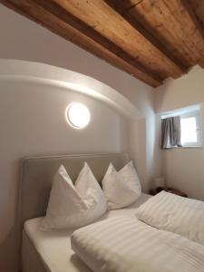 een slaapkamer met een bed met witte kussens en een raam bij City Center Golden Roof 5 in Innsbruck