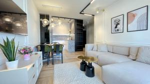 Luksusowe Apartamenty na Toruńskiej في كفيدن: غرفة معيشة مع أريكة بيضاء وطاولة