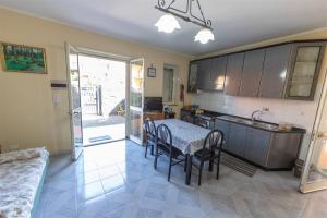 cocina y comedor con mesa y sillas en Appartanvilla con giardino terrazzo e parcheggio privato, en Mascali