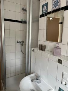 uma casa de banho branca com um lavatório e um espelho em Turmwohnung em Kreischa