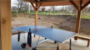 a ping pong table sitting under a gazebo at Roulotte 4pers SPA Terrain multisport in Braffais