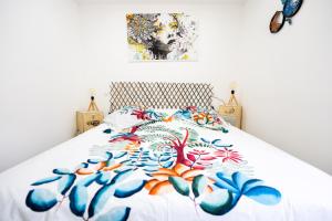 una camera da letto con un letto con copriletto floreale di Appartement des Sorcieres - Witches Apartment a Sélestat