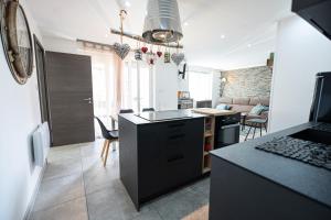 una cucina con piano di lavoro nero e un soggiorno di Appartement des Sorcieres - Witches Apartment a Sélestat