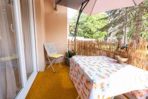 einen Balkon mit einem Tisch, einem Sonnenschirm und einem Stuhl in der Unterkunft Appartement des Sorcieres - Witches Apartment in Sélestat