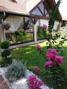 un giardino con fiori rosa e un padiglione di Neon2 - Vendégház a Orosháza