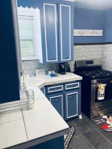 a kitchen with blue cabinets and a stove at Xscapecation Oasis in Tulsa