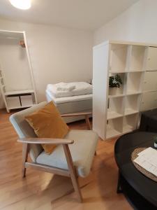 een woonkamer met een stoel en een bed bij City Center Golden Roof 5 in Innsbruck