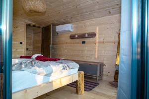 1 dormitorio con 1 cama y pared de madera en Villa Tramonto D'Oro en Ulcinj