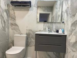 a bathroom with a toilet and a sink and a mirror at Valkla Puhkekeskus - Merevaatega SVIIT in Salmistu