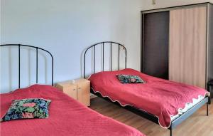 2 Betten in einem Schlafzimmer mit roter Bettwäsche und Luftmotte in der Unterkunft Awesome Home In Suleczyno With Kitchen in Sulęczyno