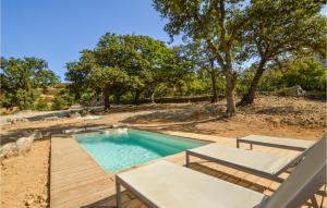 a swimming pool with two chairs and a wooden deck at Beautiful Home In Feliceto With Wifi in Feliceto