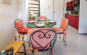 comedor con mesa y sillas rosas en Cozy Apartment In L'estartit With Wifi, en L'Estartit