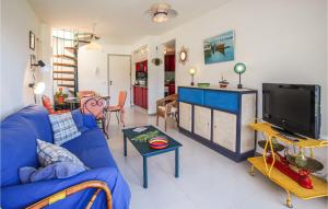 un salon avec un canapé bleu et une télévision dans l'établissement Cozy Apartment In Lestartit With Wifi, à L'Estartit