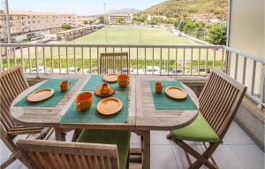 - une table avec des assiettes et des tasses sur un balcon avec un court de tennis dans l'établissement Cozy Apartment In Lestartit With Wifi, à L'Estartit